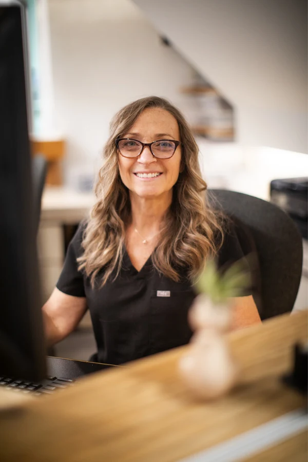 A smiling team member at the High Park Smile Studio reception desk